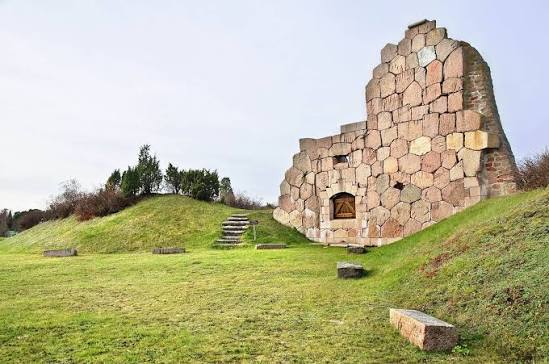 Bomarsunds fästningsruin – stenmur bland gröna grässluttningar